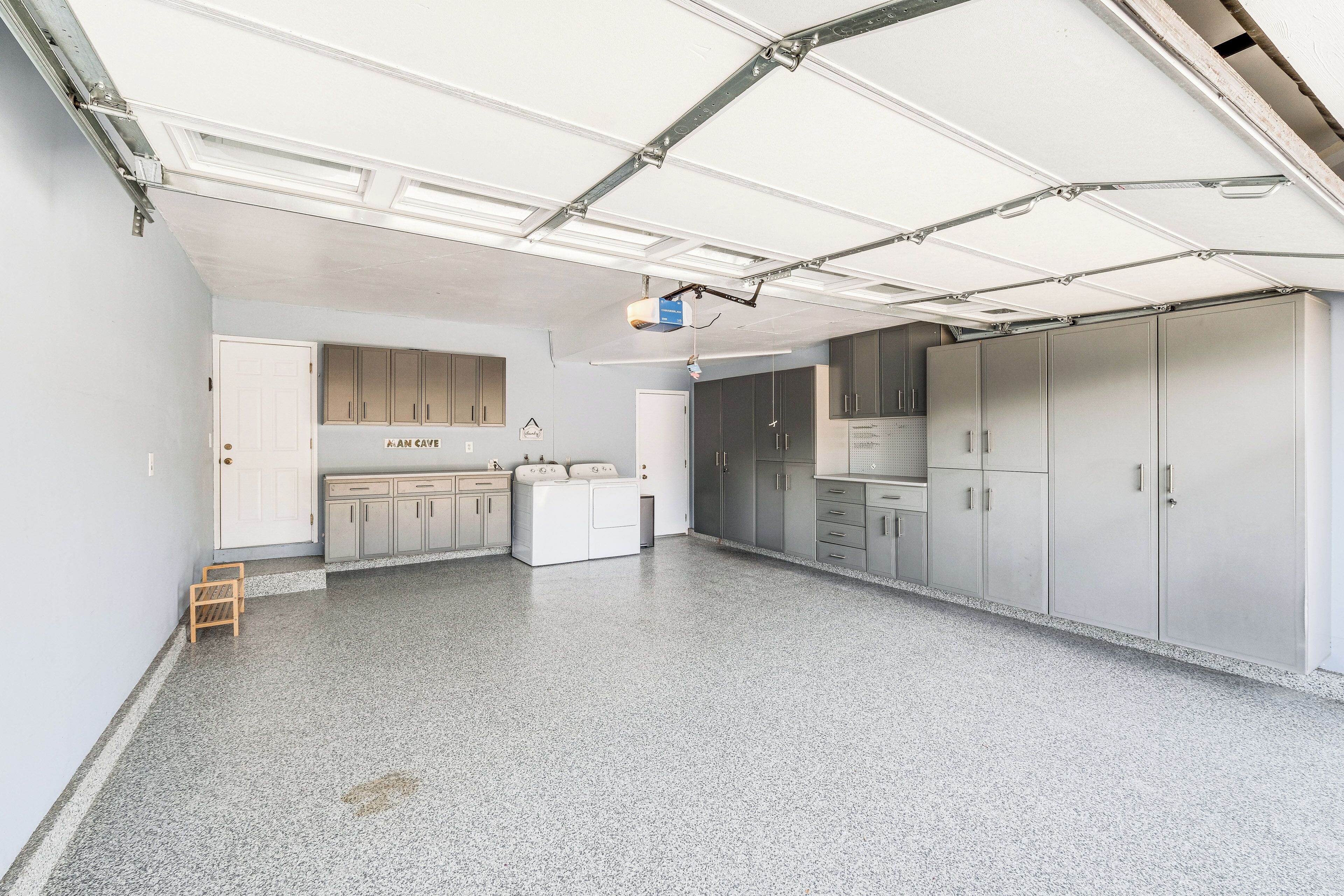 Una habitación amplia con kitchenette, lavadora y secadora integradas, y un armario grande.