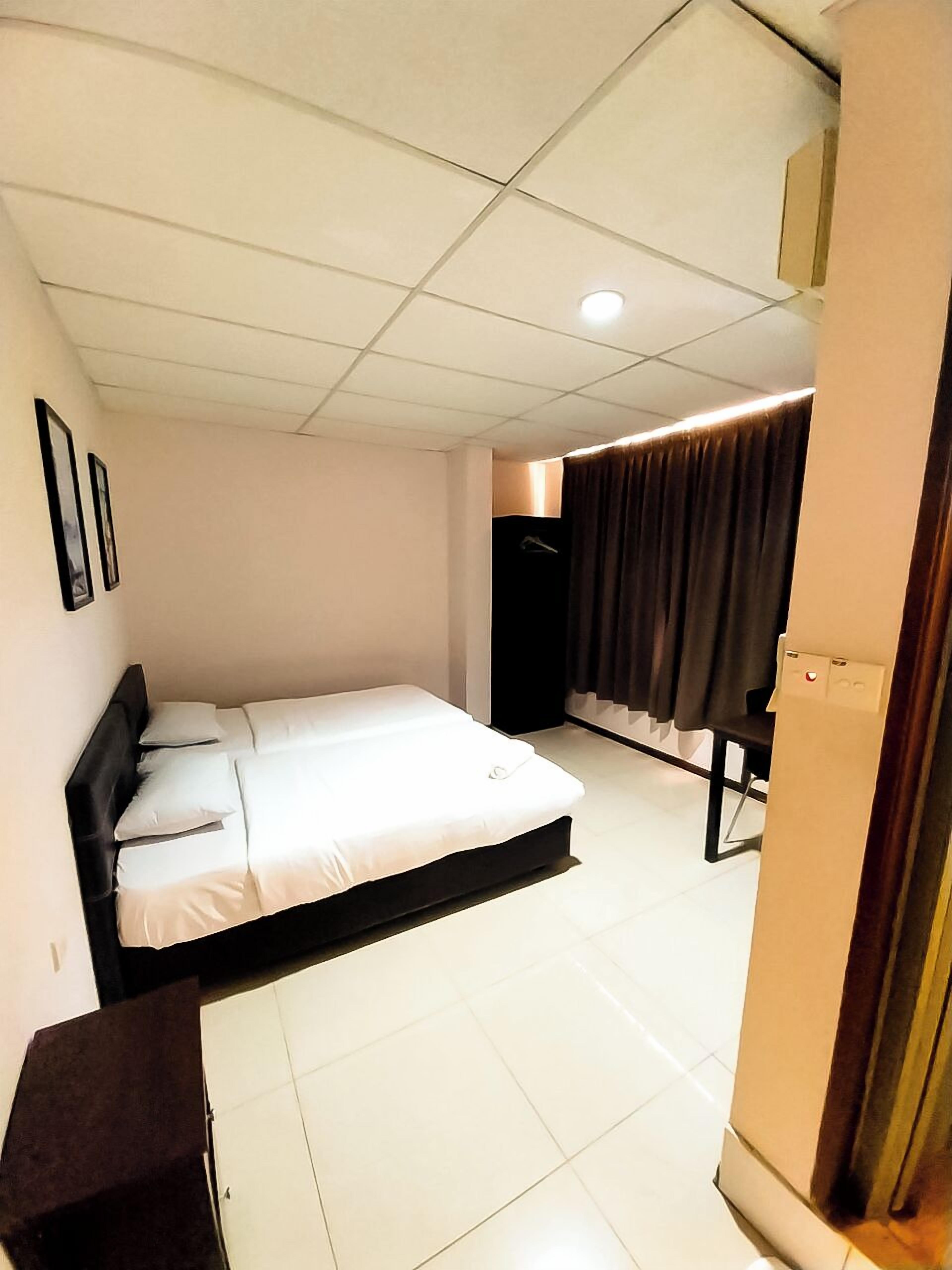 Una camera d'albergo con un letto, un armadio e una tenda.
