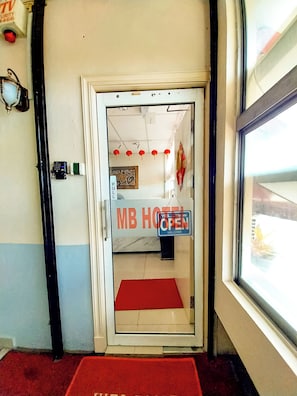 A hotel entrance with a red carpet, a 'MB HOTEL' sign, and a 'PULL' sign. - MB Budget Hotel (Kota Kinabalu)
