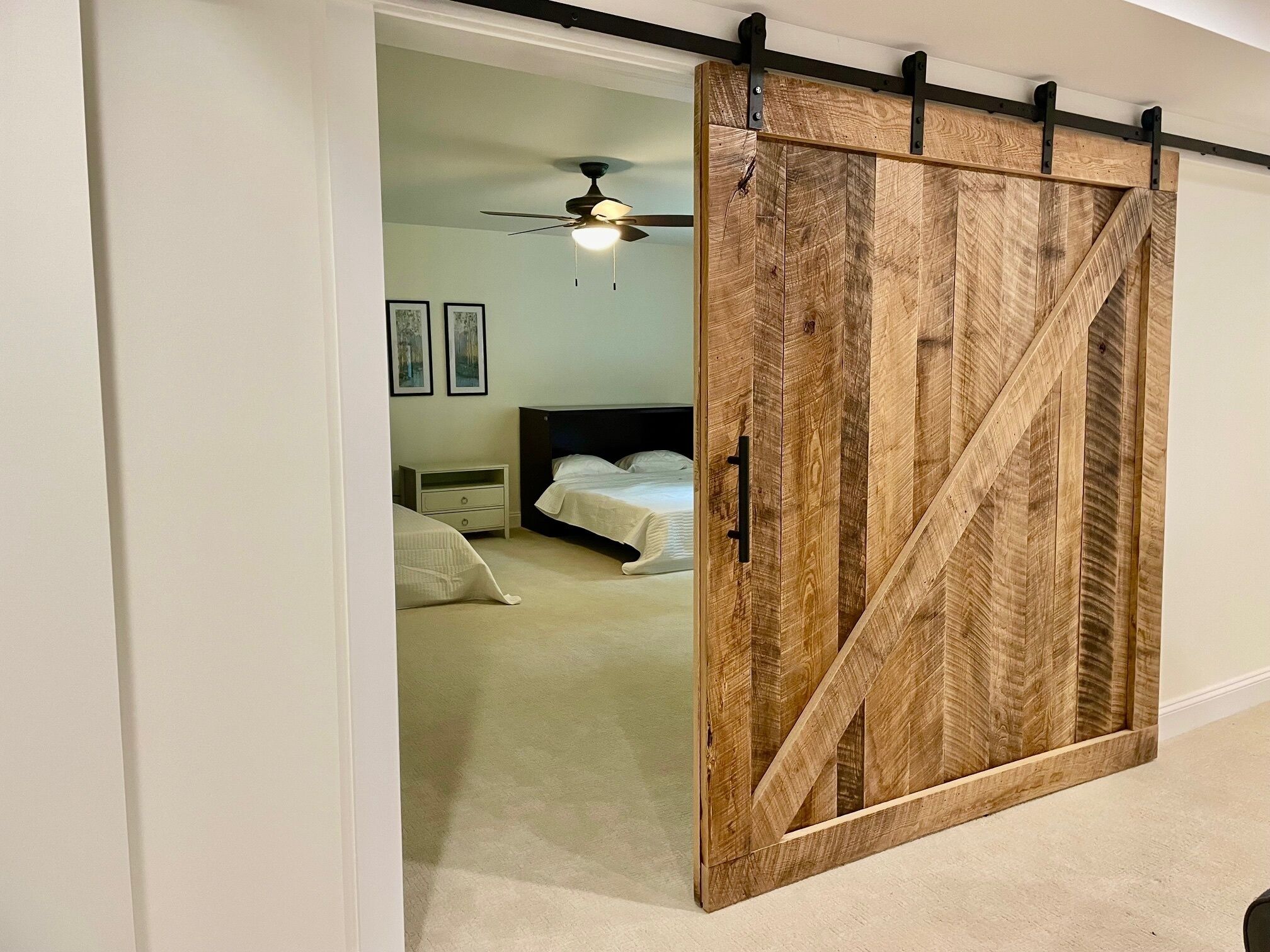 Un dormitorio con cama, mesita de noche, cómoda y ventilador de techo.