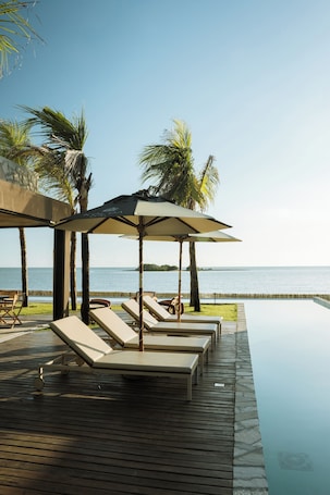 Una piscina al aire libre, sillones reclinables de piscina