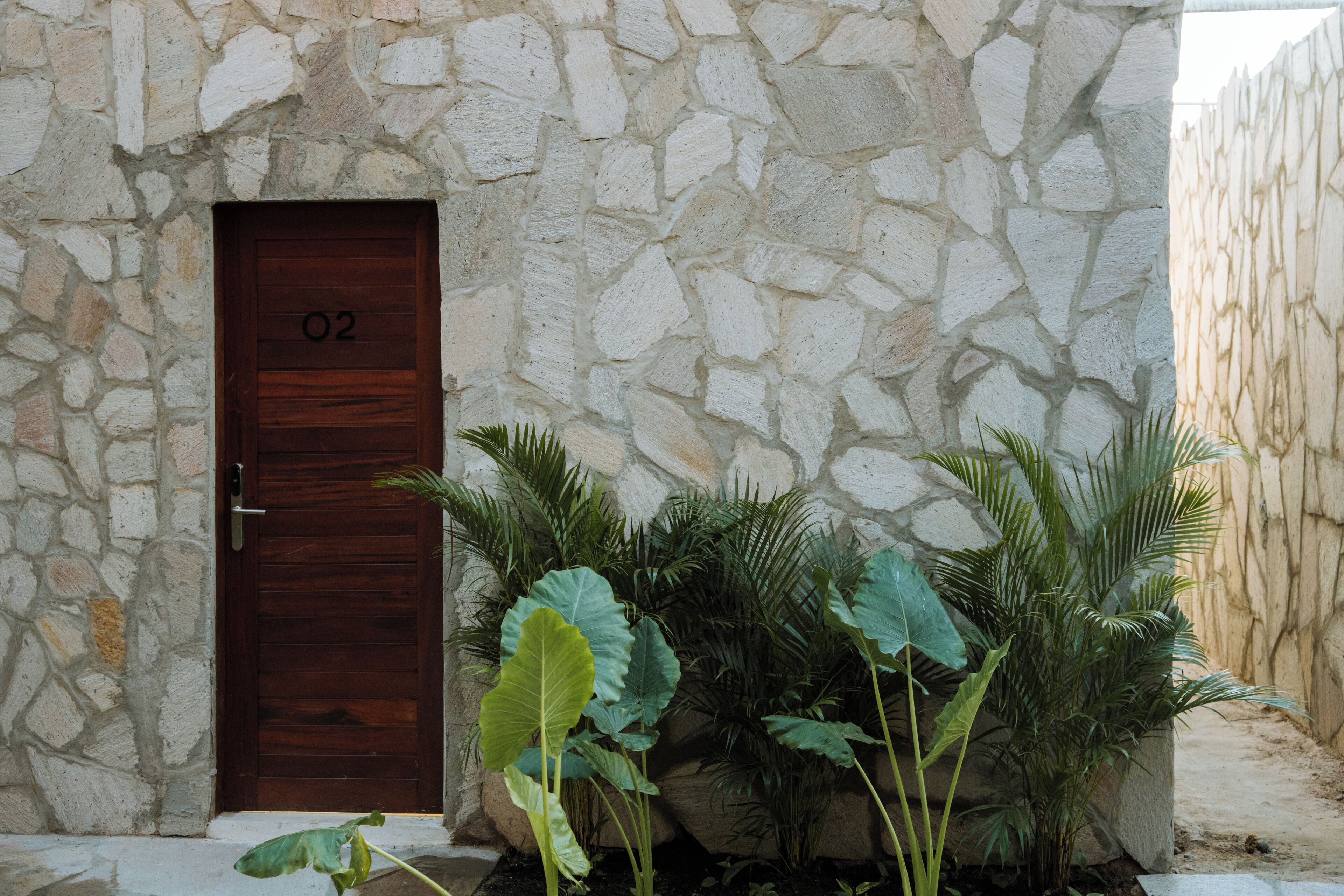 A stone building with a wooden door labeled "02".