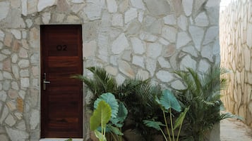 A stone building with a wooden door labeled "02".