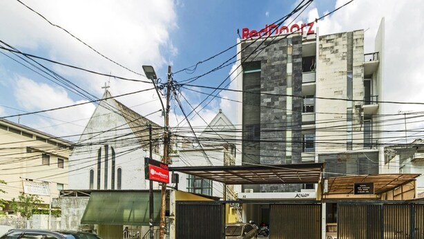 A building with a sign 'RedDoorz' and a gated entrance. - Reddoorz Plus @ Pasar Baru (Jakarta)