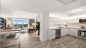 A modern apartment with a kitchen, living area, and a view of the city.