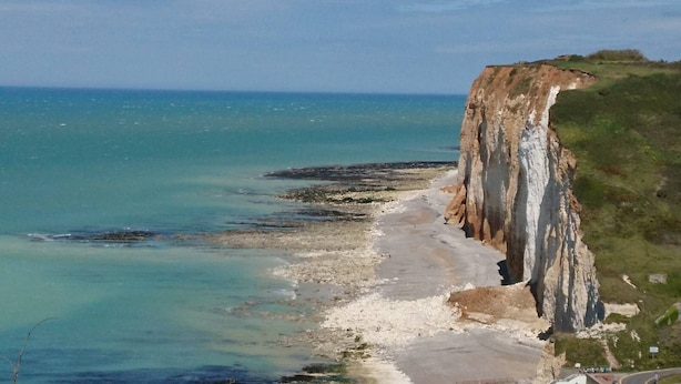 A coastal landscape with cliffs and a beach.
