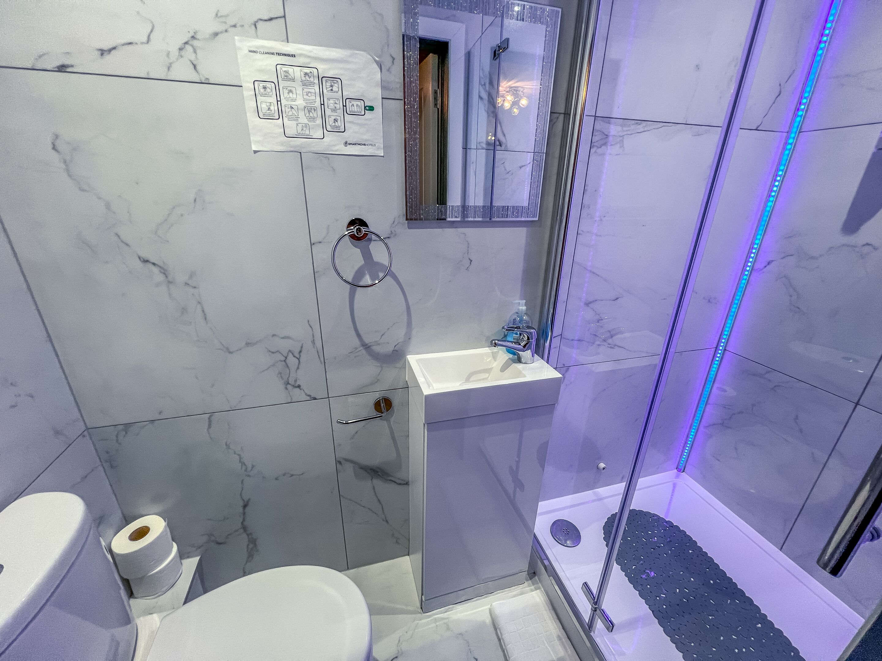 Un baño con inodoro, lavamanos y ducha.