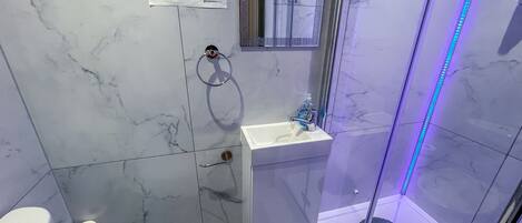 Un baño con inodoro, lavamanos y ducha.