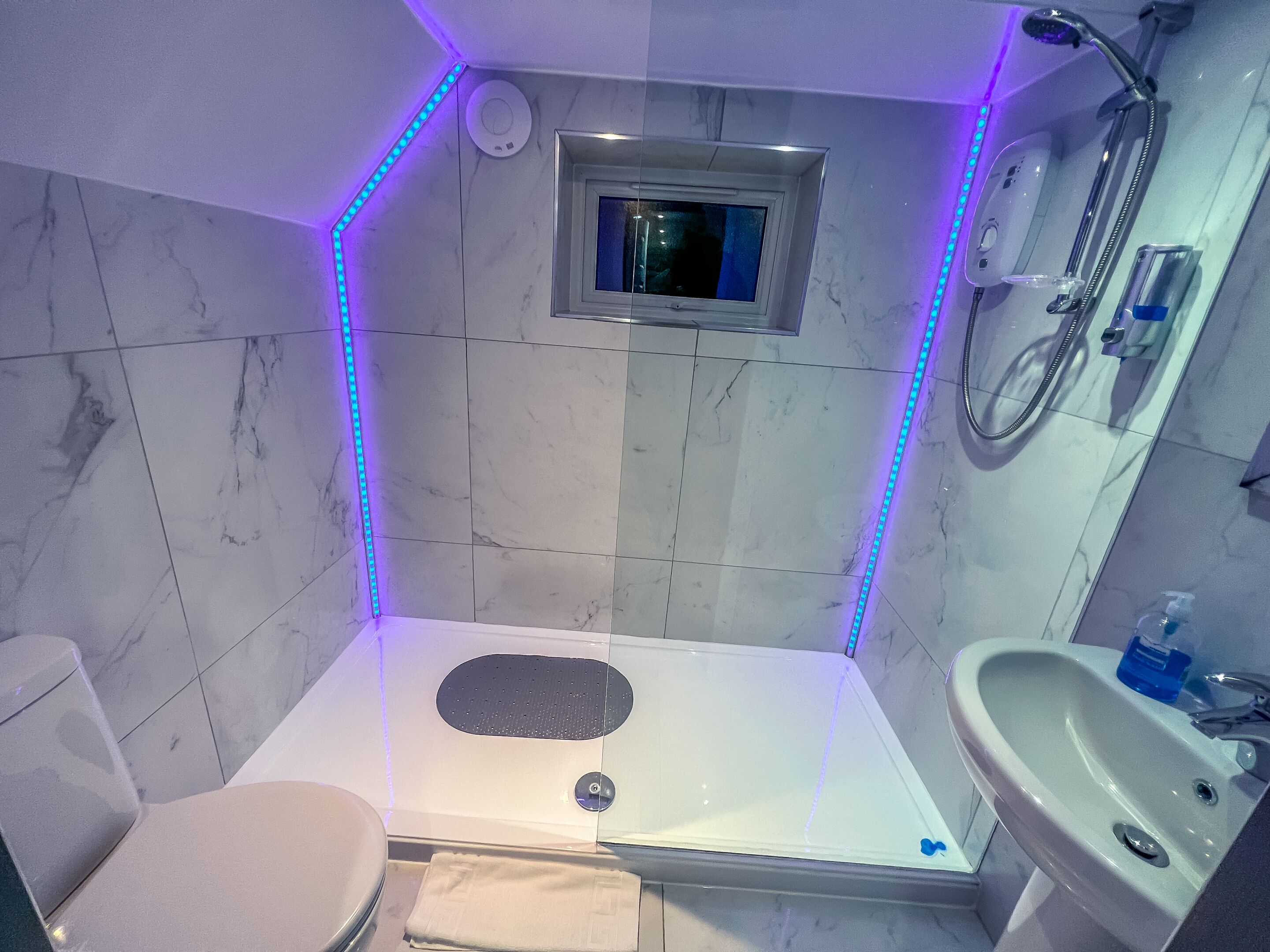 A bathroom with a shower, toilet, and sink.