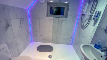 A bathroom with a shower, toilet, and sink.