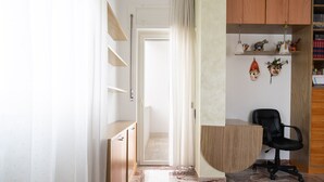 Een slaapkamer met een bed, een bureau, een stoel en een kledingkast.