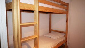 A bunk bed with a wooden frame and a mattress.
