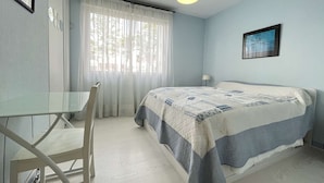 A bedroom with a bed, a desk, and a chair. - T2 Apartment with Parking near La Rochelle Old Port (La Rochelle)