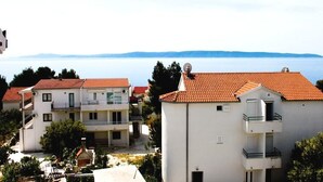 A coastal residential area with white buildings and red-tiled roofs. - Niko (Okrug)