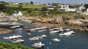 A coastal village with numerous boats docked at a harbor, surrounded by houses and greenery. - Maison Pour 6 Personnes, 150 m de la Mer, 4mn à Pied du Port de Pors Poulhan (Plozévet)