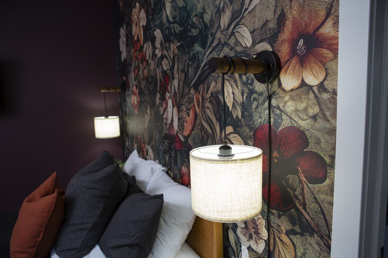Ein Bett mit Kissen und eine Wand mit floralem Wandbild.