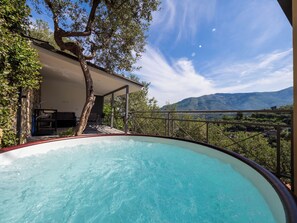 A swimming pool with a view of mountains and a tree. - Regina Vittoria Relais (Vico Equense)