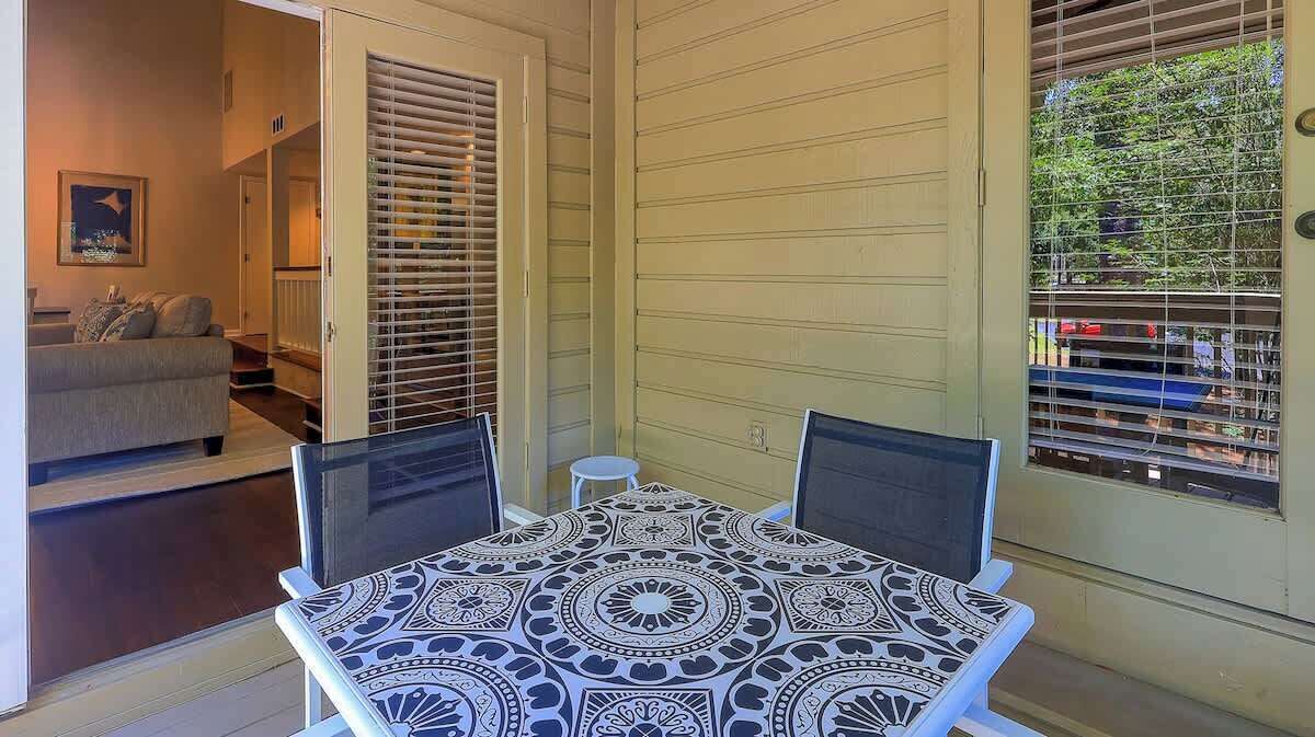 A patio with a table and chairs, a sliding door, and a view of the outdoors.