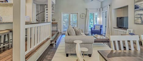 A spacious living area with a sofa, a dining table, and a TV.