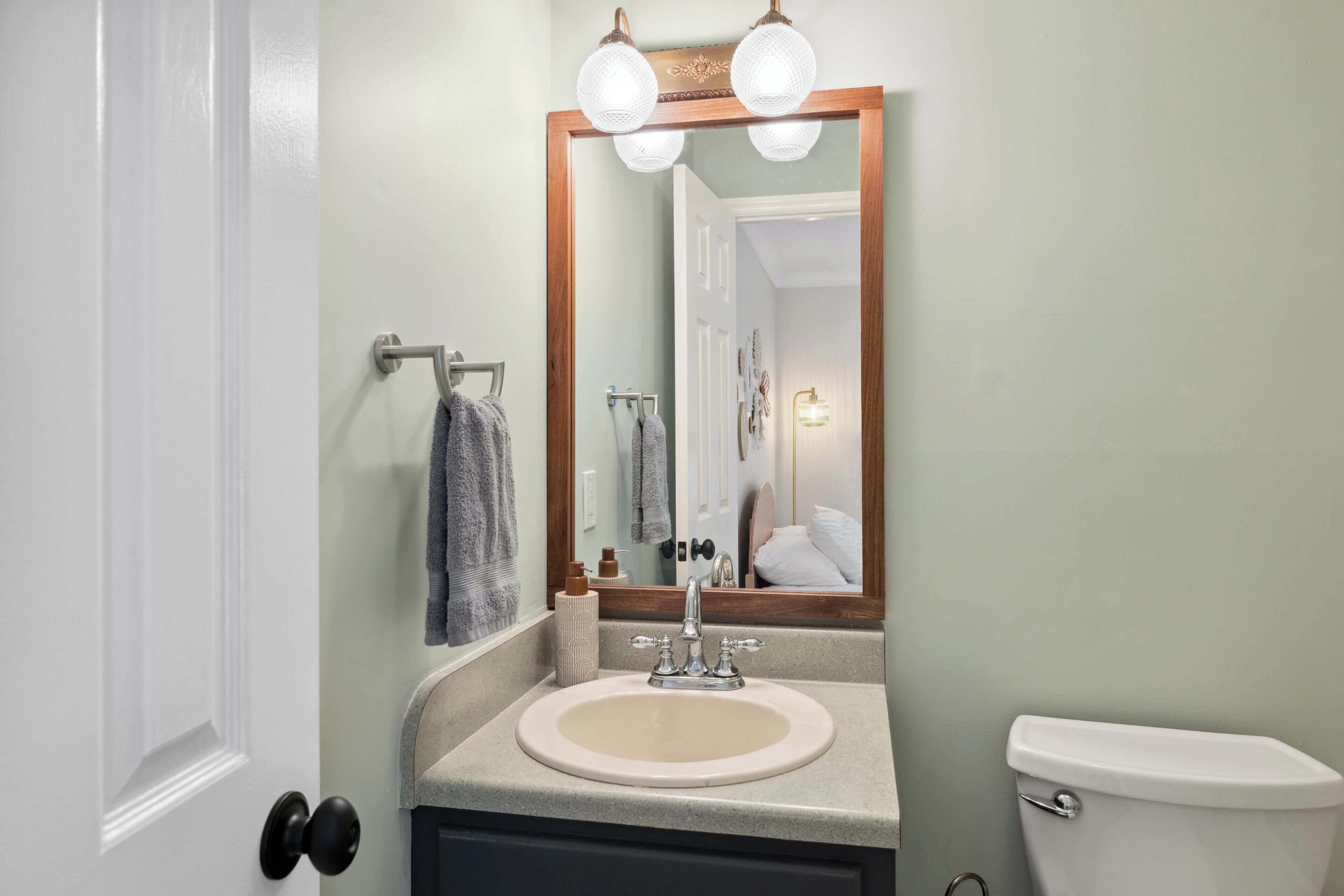 A bathroom with a sink, mirror, and toilet.
