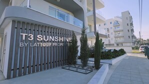 Ein modernes Apartmenthaus mit Balkonen und einem Schild mit der Aufschrift "T3 Sunshine by Lattouf Properties".