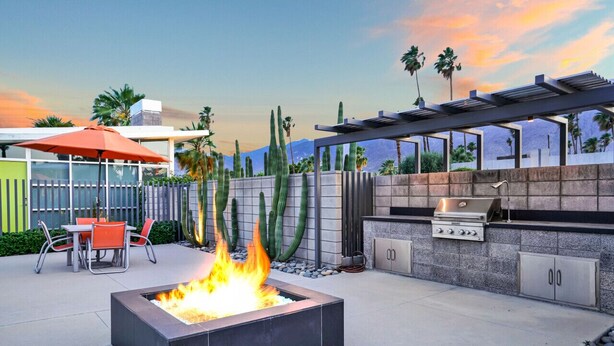 An outdoor patio with a fire pit, a grill, and a seating area with chairs. - The Vista: Colorful & Vibrant Palm Springs Escape (Palm Springs)