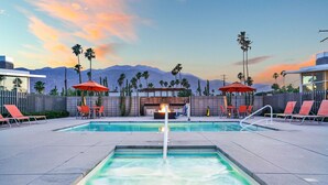 A rooftop pool area with two pools, lounge chairs, and umbrellas. - The Vista: Colorful & Vibrant Palm Springs Escape (Palm Springs)