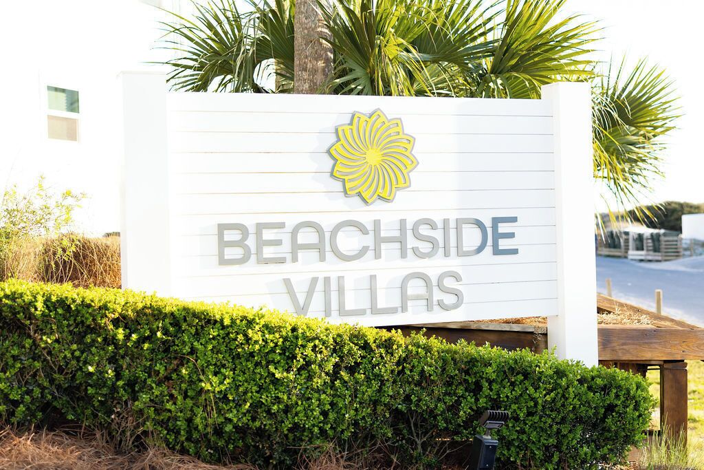 A sign for Beachside Villas with a logo and the name of the property.