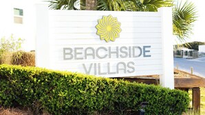 Placa para Beachside Villas com um logotipo.