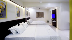 Une chambre d’hôtel moderne équipée de deux lits, d’un téléviseur à écran plat et agrémentée d’œuvres d’art aux murs.