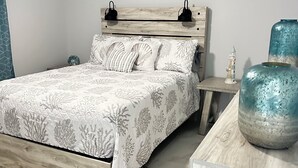 A bedroom with a bed, nightstands, decorative vases, and a ceiling fan. - Home Away From Home! (Vero Beach)