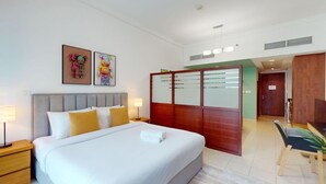 A hotel room with a large bed, bedside tables, a desk, and a wardrobe.