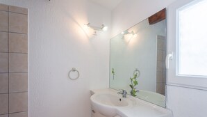 A bathroom with a white sink, a mirror, and a towel ring on the wall. - Côté Oliviers 6P - Appt avec piscine partagée (Beaucaire)
