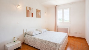 A bedroom with a bed, nightstand, and two wall-mounted light fixtures. - Côté Oliviers 6P - Appt avec piscine partagée (Beaucaire)