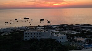 A coastal town at sunset with buildings near the water, a clear sky, and calm sea. - Room with terrace and a wonderful view of the Bay of Citara (Forio)