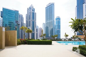 Relax by the pool surrounded by lush greenery and modern architecture.