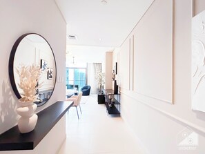 Relax in a serene space with a comfortable sofa and chair, surrounded by a beautiful floral arrangement and a large mirror.
