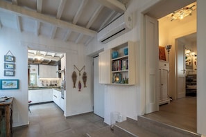 Un intérieur moderne comprenant une cuisine, des étagères ouvertes et un escalier.