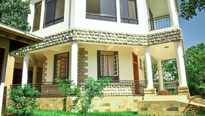 A two-story building with a stone facade, multiple windows, and a balcony.