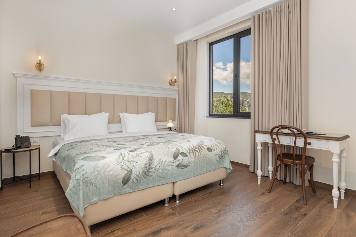 A bedroom with a bed, a desk, and a chair.