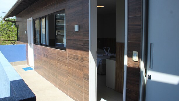 Un edificio moderno con fachada de madera, un balcón y una habitación con una cama y una decoración con forma de corazón.
