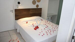 Una cama bien hecha con cabecera de madera, una lámpara de pared y decoración mural.
