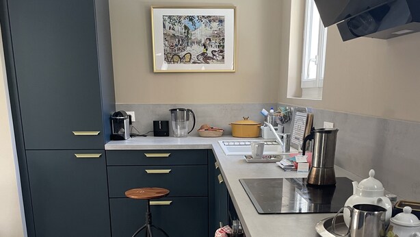 A modern kitchen with dark cabinets, a countertop, and a window.