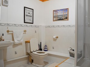 A bathroom with a toilet, sink, and a framed bathroom rules sign. - 2 bedroom accommodation in Carterton (Carterton)