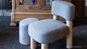 Een houten kast met glazen deuren, gevuld met diverse spullen zoals schoenen en tassen.