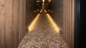 A hallway with patterned carpet, wooden walls, and a central light fixture. - MAYBEN HOTEL  (Çaykara)