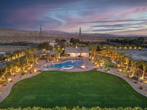 A residential property with a swimming pool, landscaped garden, and a view of the surrounding desert landscape. - 360° Mountain Views | 3 Acres Massive Resort Pool (Thousand Palms)