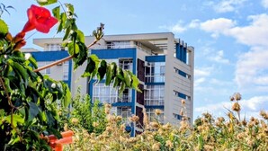 Un edificio moderno con varios pisos, ventanas amplias y balcones.
