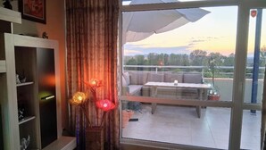 Una habitación con un amplio ventanal corredera que da a una zona de estar exterior.