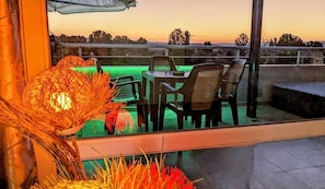 Un espace extérieur aménagé avec une table et des chaises, une lampe décorative et une vue sur le paysage.